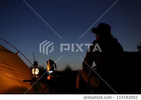 Man enjoying camping at sunset 114192002