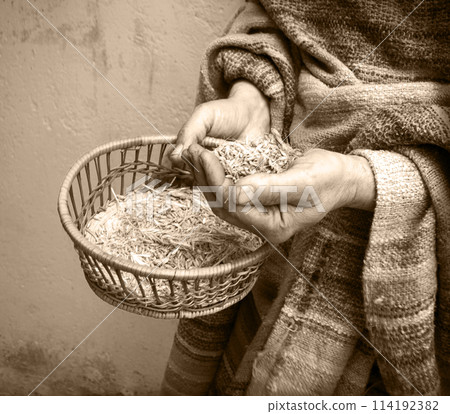 Farmer holds a sieve in his hands and sifts grain 114192382