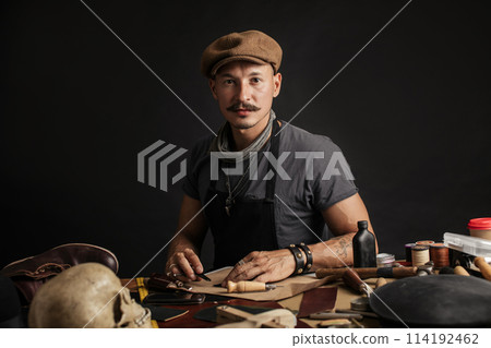 Professional shoemaker in his workshop making and repairing custom made shoes Professional shoemaker in his workshop making and repairing custom made shoes 114192462