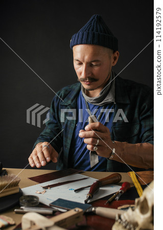 Shoemaker is repairing shoe. Shoemaker sews shoes. Cobbler workshop. Shoemaker is repairing shoe. Shoemaker sews shoes. Cobbler workshop. 114192579