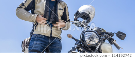 A male rider wearing a separate chest protector A male rider wearing a separate chest protector 114192742