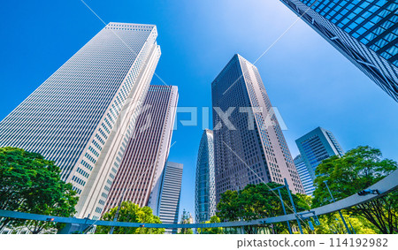Shinjuku, Tokyo cityscape in Japan. View of Nishi-Shinjuku sign at the intersection behind Shinjuku Police Station and skyscrapers, April 28th 114192982