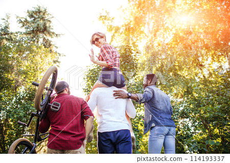 Young coupe in park. Boyfriend carrying his girlfriend on piggyback. 114193337
