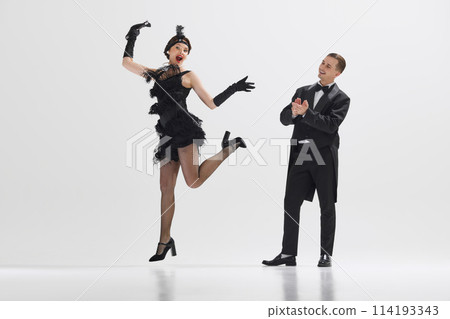 Handsome man looking at beautiful woman dancing and clapping with admiration isolated over white studio background 114193343