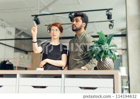 business partners standing in office building and talking about deals, woman showing coworker his new office place business partners standing in office building and talking about deals, woman showing coworker his new office place 114194632
