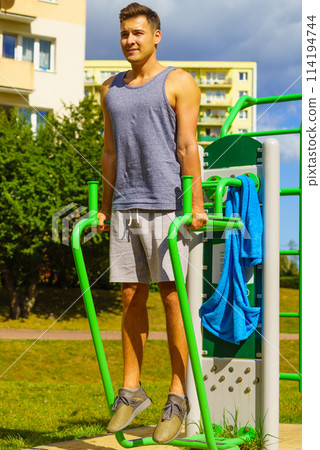 Man doing sit ups in outdoor gym 114194744