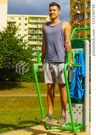 Man doing sit ups in outdoor gym 114194748