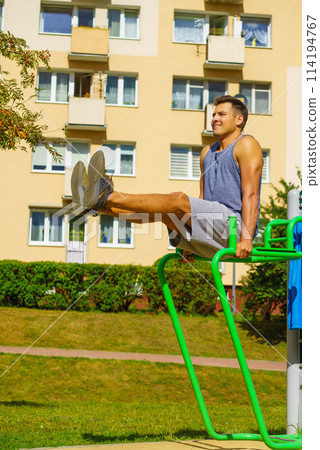 Man doing sit ups in outdoor gym 114194767