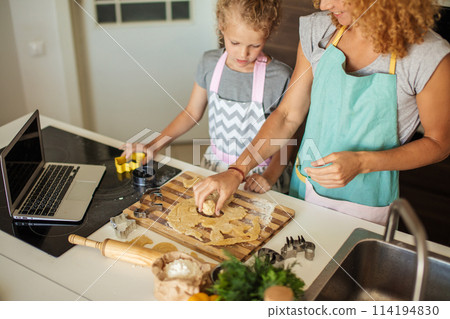Child and women cutting form for cookie in dough. Happy family and childhood. Child and women cutting form for cookie in dough. Happy family and childhood. 114194830