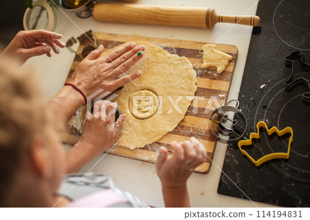 Child and women cutting form for cookie in dough. Happy family and childhood. Child and women cutting form for cookie in dough. Happy family and childhood. 114194831