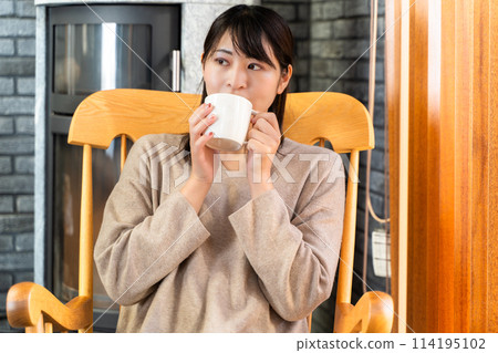 Woman relaxing in a rocking chair Woman relaxing in a rocking chair 114195102