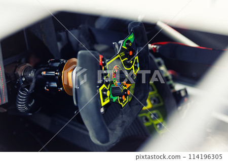 Detailed view of a high-tech racing car steering wheel, gear shift controls and settings. Interior professional race car drivers technology engineering speed in motorsport competition Detailed view of a high-tech racing car steering wheel, gear shift controls and settings. Interior professional race car drivers technology engineering speed in motorsport competition 114196305