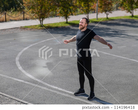 Bearded man doing exercises outdoors.  114196418