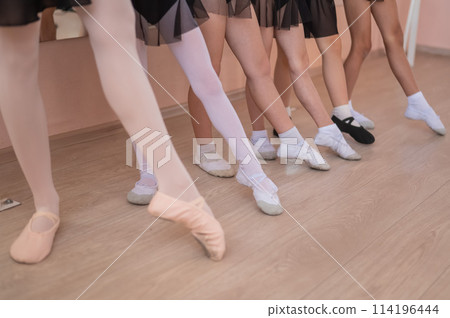 Close-up of feet of 5 little girls and teacher at ballet class. Close-up of feet of 5 little girls and teacher at ballet class. 114196444