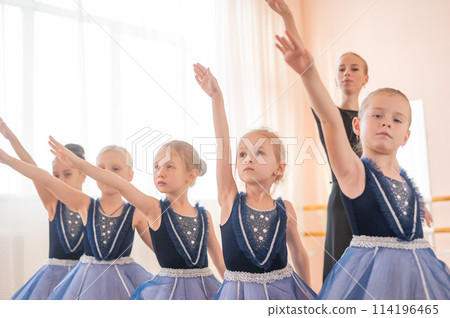 Children's ballet school. Caucasian woman teaching ballet to little girls.  114196465