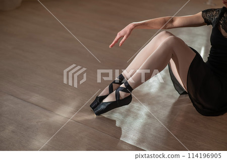 Close-up of the legs of a ballerina sitting on the floor. Close-up of the legs of a ballerina sitting on the floor. 114196905