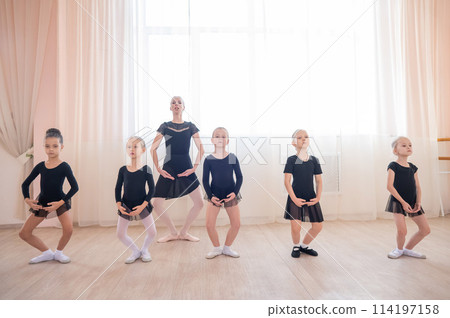 Children's ballet school. Caucasian woman teaching ballet to little girls.  114197158