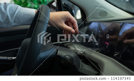 A man removes the protective film from the dashboard of a new car. A man removes the protective film from the dashboard of a new car. 114197345