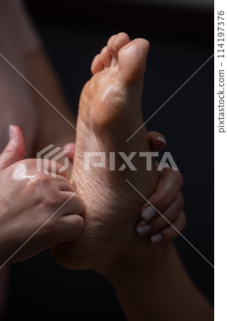 Close-up of a woman's foot massage. Vertical photo. Close-up of a woman's foot massage. Vertical photo. 114197376