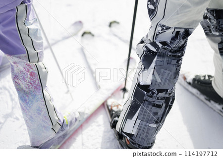 Father and daughter enjoying skiing on snowy mountain 114197712