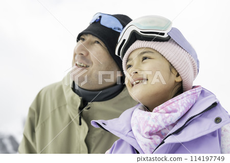 Father and daughter enjoying skiing on snowy mountain 114197749