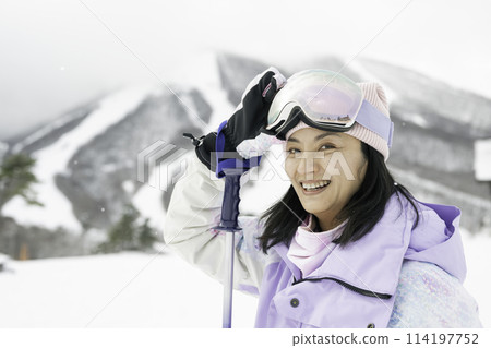 A woman in her 40s enjoying skiing on a snowy mountain A woman in her 40s enjoying skiing on a snowy mountain 114197752