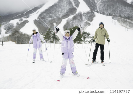 一家人在雪山上享受滑雪，父親和女兒 114197757