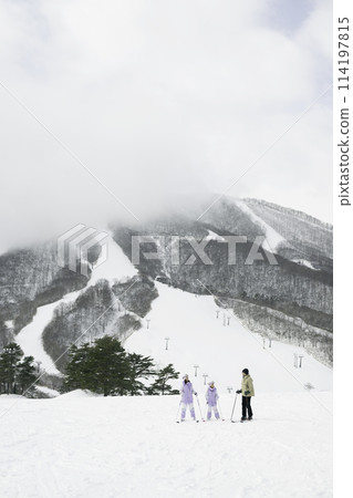 Family, parents and daughter enjoying skiing on snowy mountain 114197815
