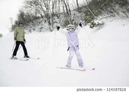 父親和女兒在雪山上享受滑雪的樂趣 114197828