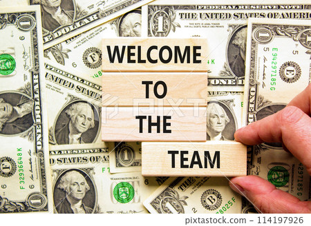 Welcome to the team symbol. Concept words Welcome to the team on wooden block. Dollar bills. Beautiful background from dollar bills. Business, motivational and welcome to the team concept. 114197926