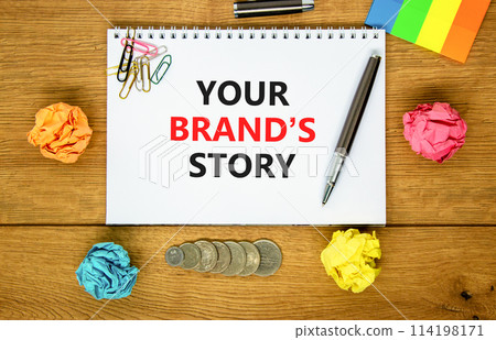 Branding and your brand story symbol. Concept words Your brands story on beautiful white note. Beautiful wooden background. Pen. Colored paper. Business branding your brand story concept. Copy space. Branding and your brand story symbol. Concept words Your brands story on beautiful white note. Beautiful wooden background. Pen. Colored paper. Business branding your brand story concept. Copy space. 114198171