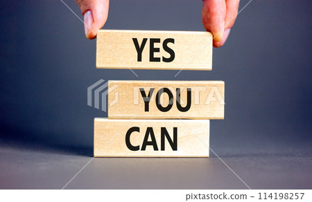 Motivational and Yes you can symbol. Concept words Yes you can on beautiful wooden blocks. Beautiful grey background. Businessman hand. Business motivational and Yes you can concept. Copy space. 114198257