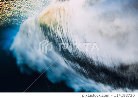 Barrel wave crashing in ocean with sunset sunlight. Underwater view of surfing wave with long shutter speed Barrel wave crashing in ocean with sunset sunlight. Underwater view of surfing wave with long shutter speed 114198720