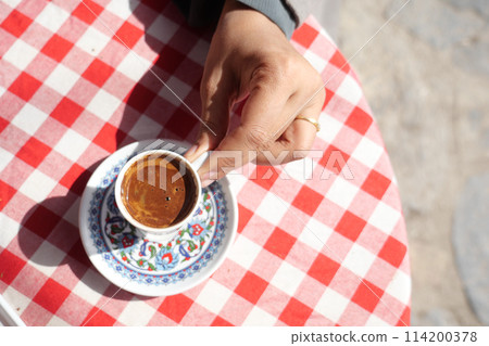 top view of holding a a cup of turkish coffee on table  114200378