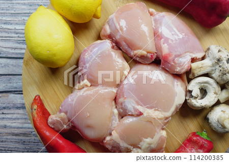 raw breast chicken meat and vegetables on a chopping board raw breast chicken meat and vegetables on a chopping board 114200385