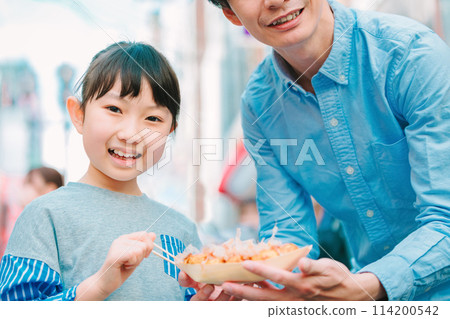 Parents and children eating Takoyaki while sightseeing in Dotonbori, Osaka 114200542