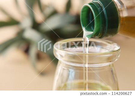 pouring natural olive oil from a bottle pouring natural olive oil from a bottle 114200627