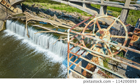 Maumee River Dam rusty wheel equipment and railing with logs above waterfall Fort Wayne, IN aerial Maumee River Dam rusty wheel equipment and railing with logs above waterfall Fort Wayne, IN aerial 114200893
