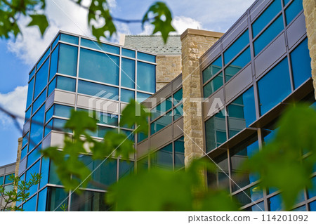 Modern Glass and Stone Building in Bloomington, Indiana with Greenery Foreground 114201092