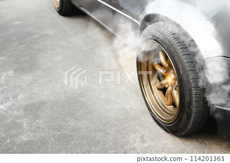 Racing car with golden wheels parked on the cement road and smoke coming from the brake system Racing car with golden wheels parked on the cement road and smoke coming from the brake system 114201363