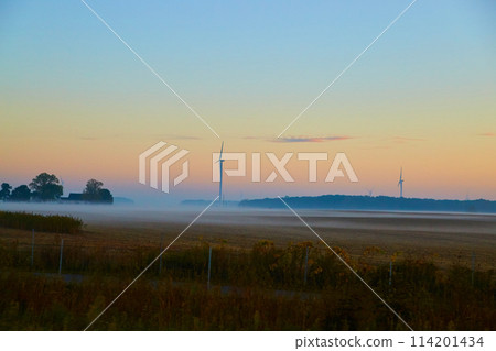 Misty Dawn over Harvested Farmland with Wind Turbines Misty Dawn over Harvested Farmland with Wind Turbines 114201434