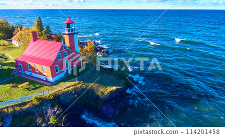 Aerial View of Eagle Harbor Lighthouse on Rocky Coast in Autumn 114201458