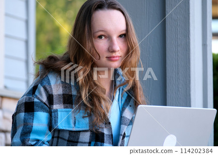 open laptop start work come home from school forget the key Woman in outerwear with long hair sitting on stairs and using laptop during work on remote project in daytime in city open laptop start work come home from school forget the key Woman in outerwear with long hair sitting on stairs and using laptop during work on remote project in daytime in city 114202384