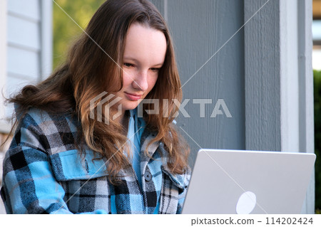 beautiful face of a young teenager girl close-up girl leaned over draws or writes looks down against very beautiful video reflections work training lessons thinking dreaming expectation sadness beautiful face of a young teenager girl close-up girl leaned over draws or writes looks down against very beautiful video reflections work training lessons thinking dreaming expectation sadness 114202424