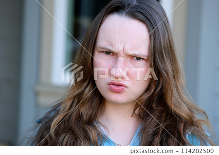 shot of dissatisfied girlfriend frowns face, raises eyebrows in bewilderment, reacts on something bad, wears casual sweater and jeans, models against pink background. Facial expressions 114202500
