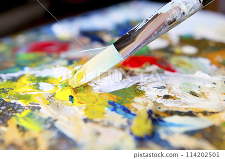 Artist's brushes and old palette with oil paints, drawing and creativity. Toned 114202501