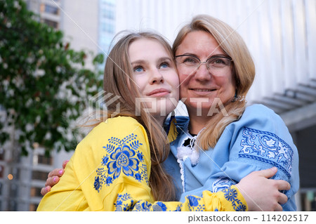 Two Ukrainian women mother and daughter look to the future Multi-colored embroidered shirts symbols of Ukraine 114202517