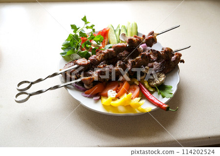 Shish kebab with mushrooms, cherry tomato and sweet pepper, Grilled meat skewers. Top view, copyspace. most important meat dish of Turkish cuisine kebabs is a rich product that is cooked on embers 114202524