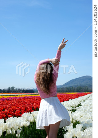 a young girl walks on a white field dancing in a white tennis skirt tenderness virginity beauty against the background of mountains Youth walk in nature in spring 114202624
