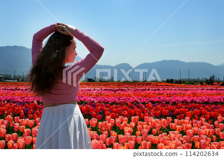 A girl playing in a flower garden A girl playing in a flower garden 114202634